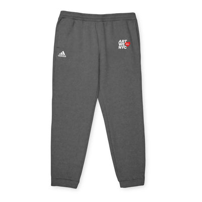 Dark gray adidas fleece joggers with elastic waistband and cuffed hems, featuring Art We All and adidas logos for unisex casual wear and sustainable comfort.